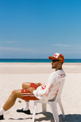model bruno wearing coke x svs pants at beach on chair