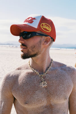 model bruno wearing hat with hibiscus flower knecklace and sandy body