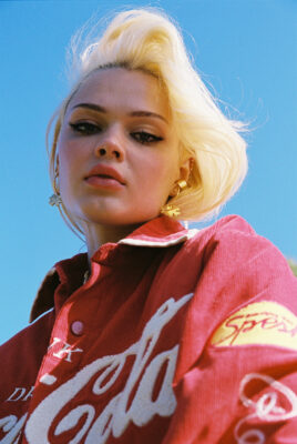 model ayla looking in camera with blue sky behind her